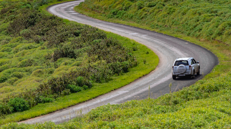 Auto en camino rodeado de naturaleza en Parque Nacional Rapa Nui